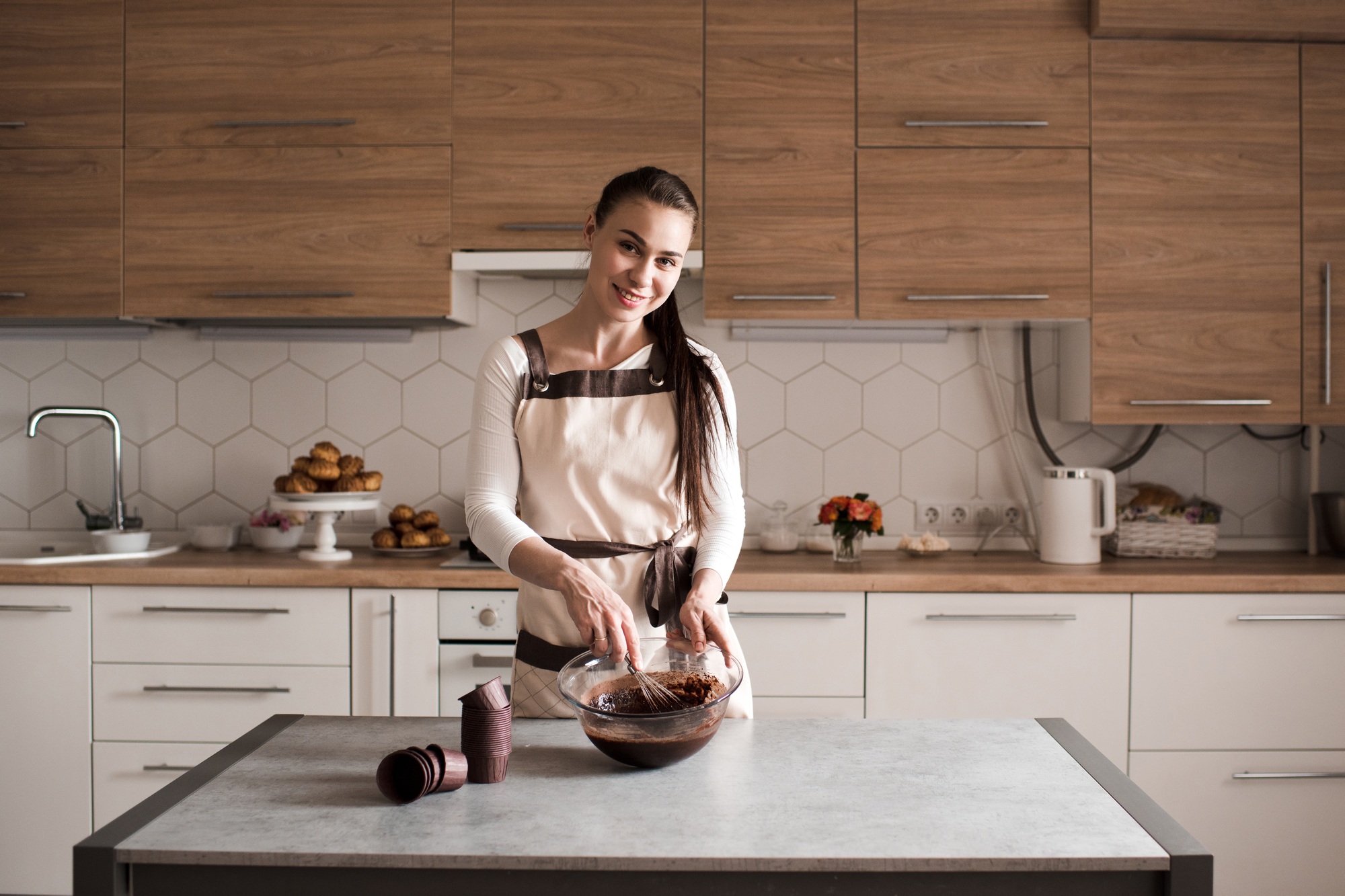Happy woman making chocolate cupcakes at home