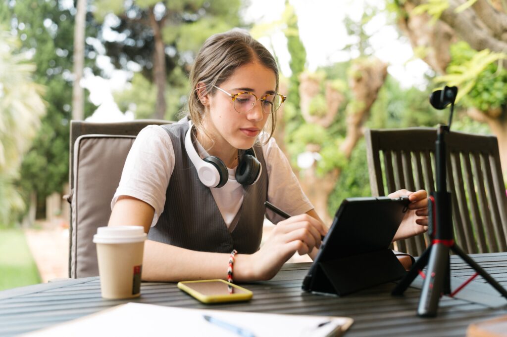 Law student using tablet and phone in garden