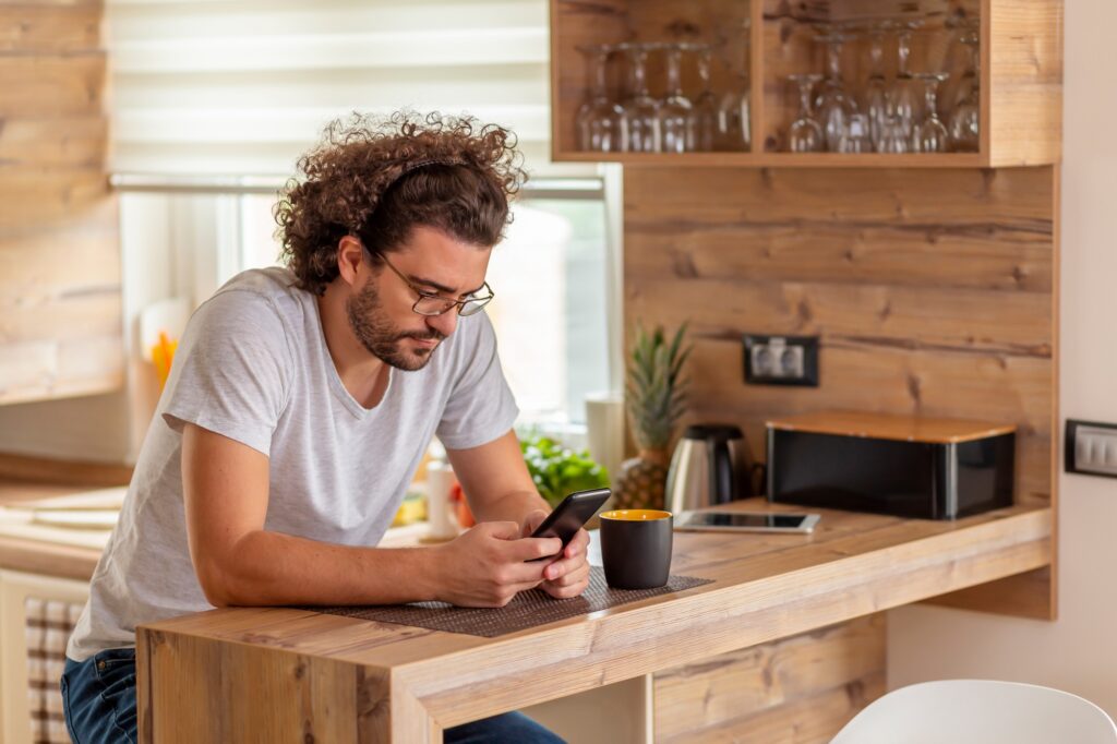Man typing a text message using smart phone