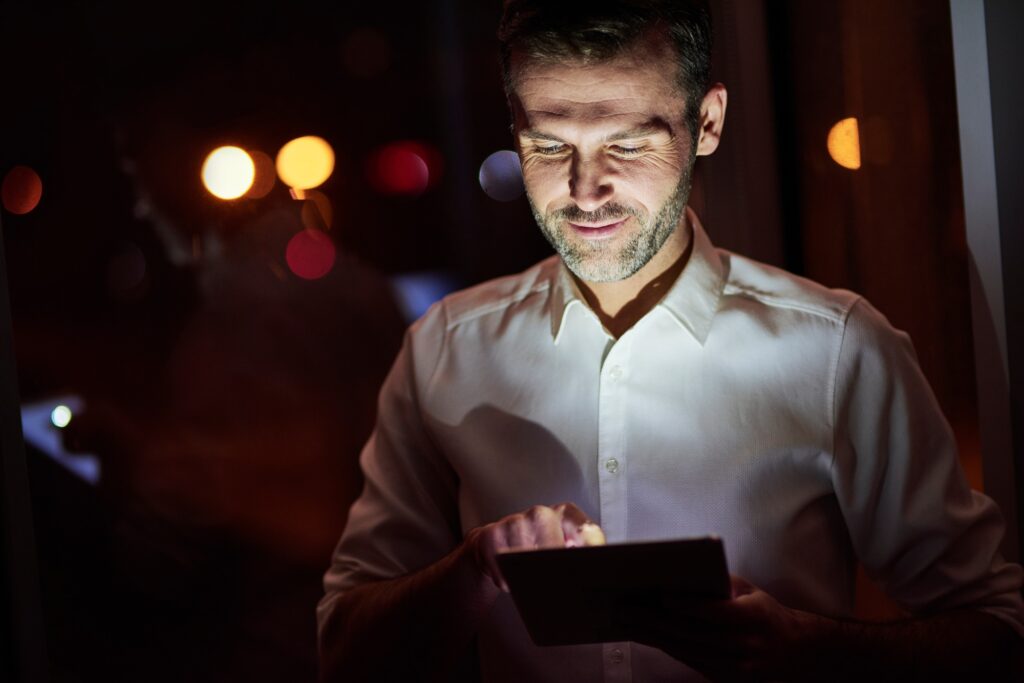 Mature men using a tablet at night