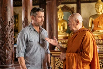 Un homme occidental face à un moine bouddhiste thaïlandais dans un temple, apprenant les codes de conduite culturels et religieux lors d'une rencontre respectueuse