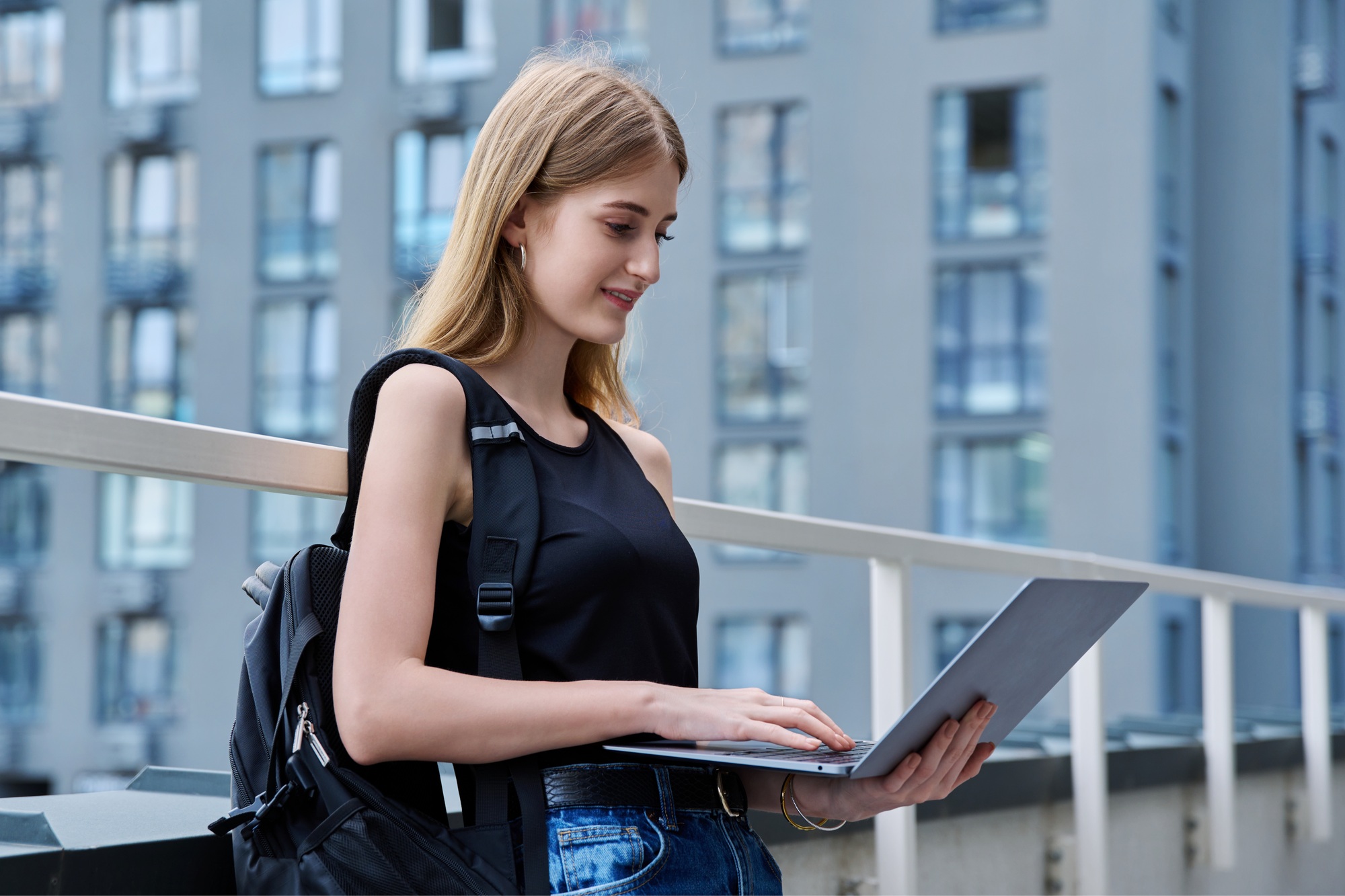 Young female college student using laptop computer outdoor